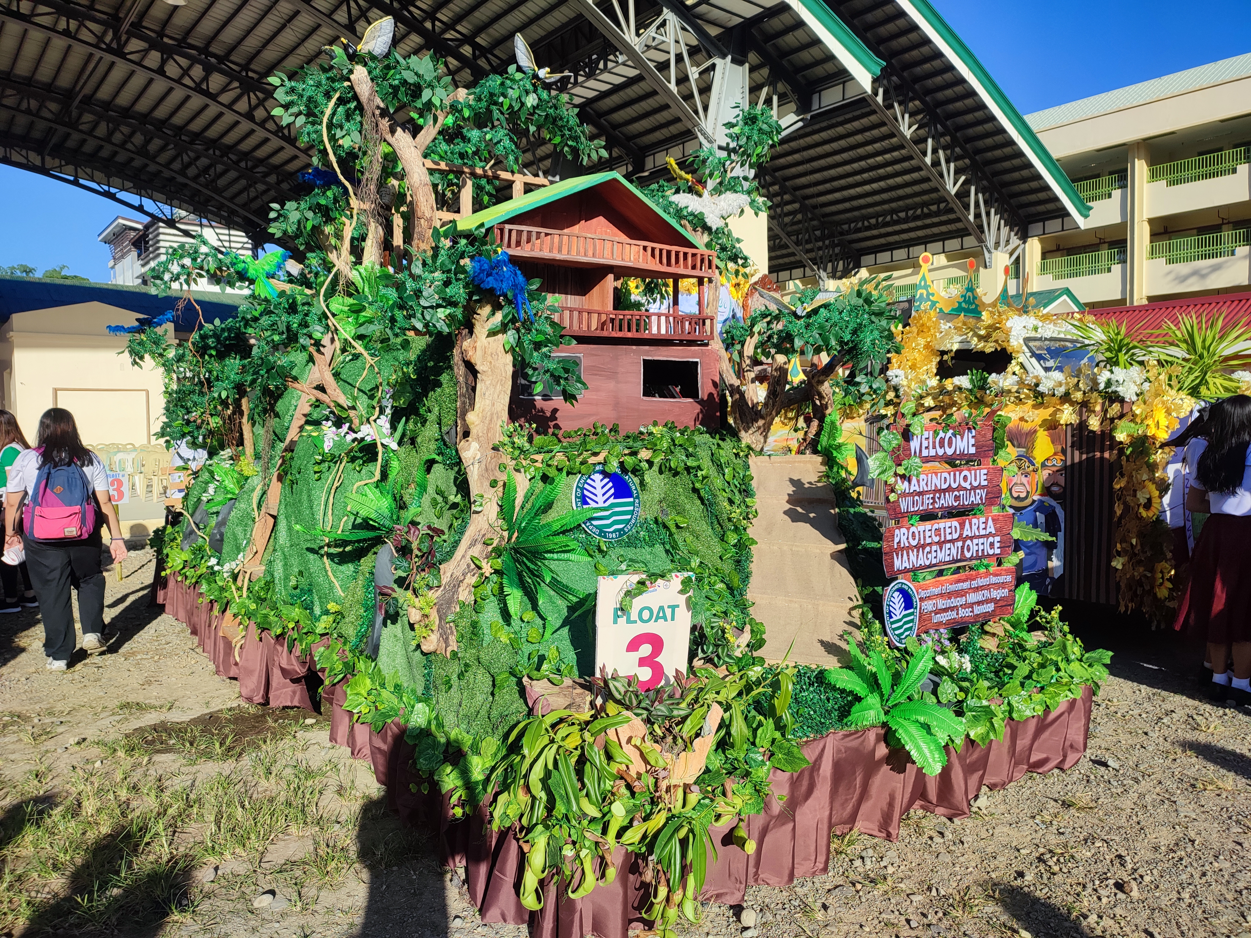 During the Grand Float Parade, showcasing DENR-PENRO MarinduqueÃ¢â‚¬â„¢s Float Ã¢â‚¬Å“Marinduque Wildlife SanctuaryÃ¢â‚¬Â, led by PENR Officer Imelda M. Diaz (in front wearing white cap).